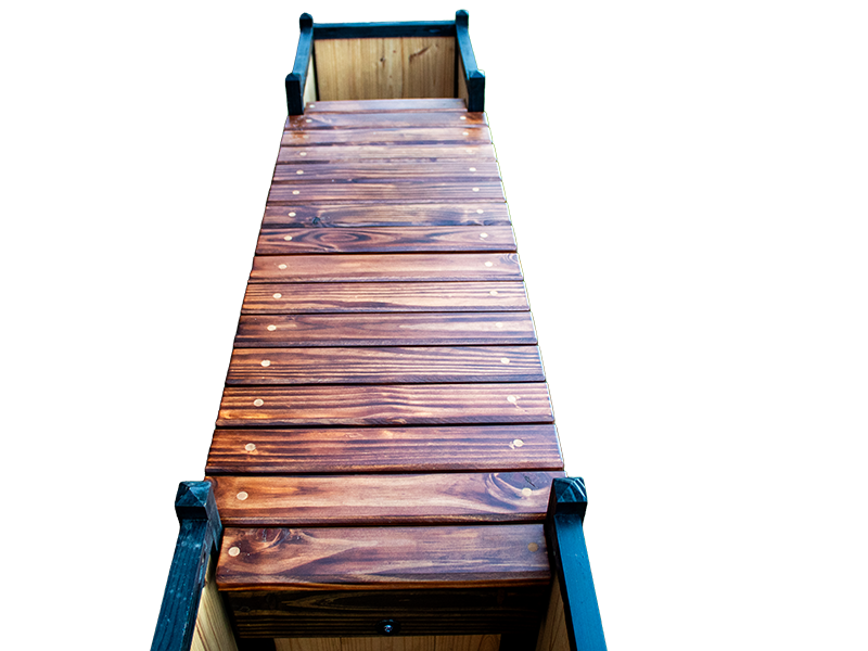 Bridge style bench in stained Mahogany and Dark Walnut colors and Red Cedar planter boxes as legs top view from the end of the bench.