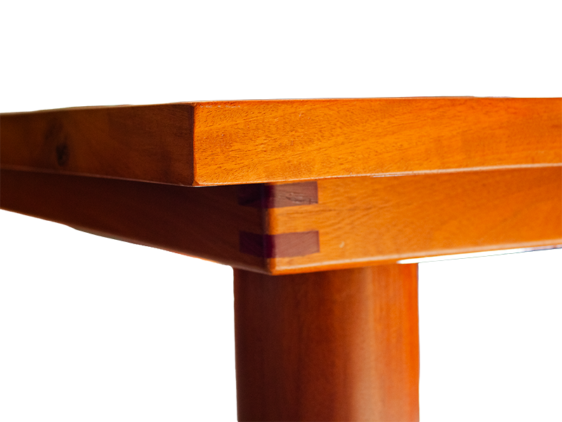 Mahogany dining table with green tile top including hand shaped cylindrical legs and Purple Heart miter spline accents corner view of Purple Heart accents.